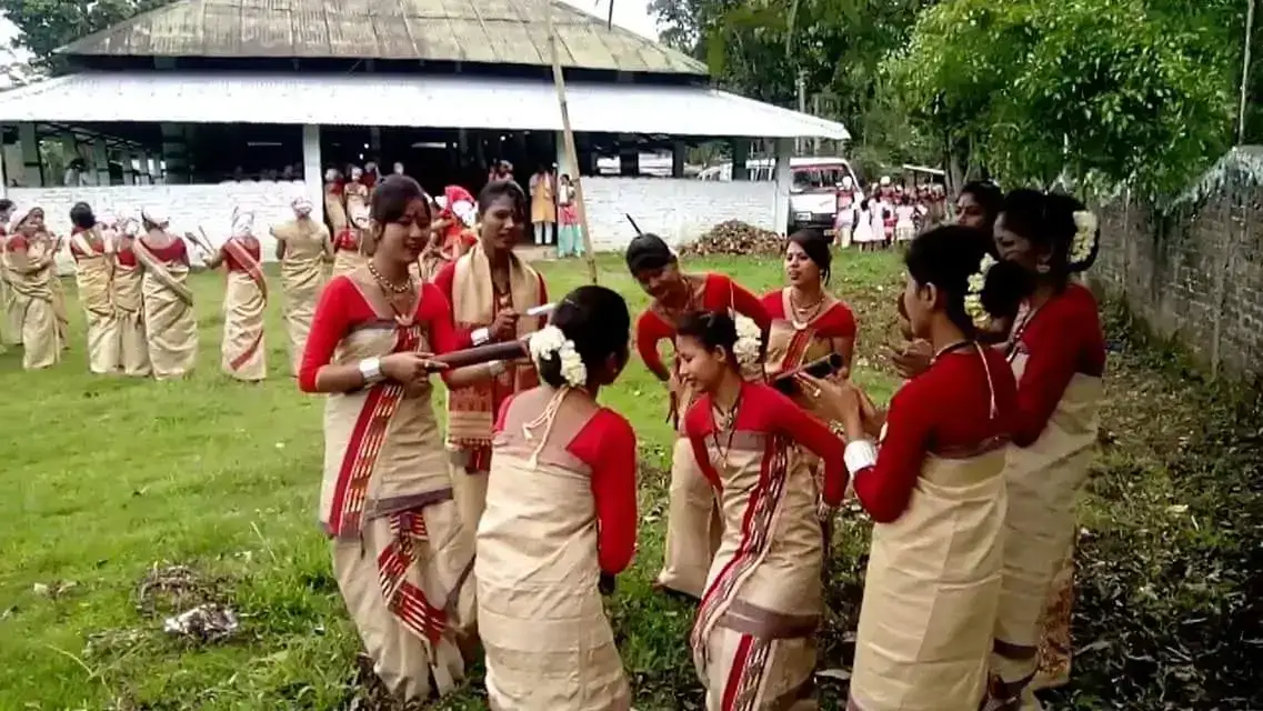Group of Bihu dancers in muga and red costumes