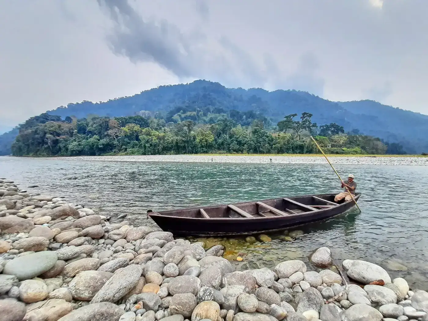 Boat on the Noa-Dihing river with forested hills in Namdapha National Park