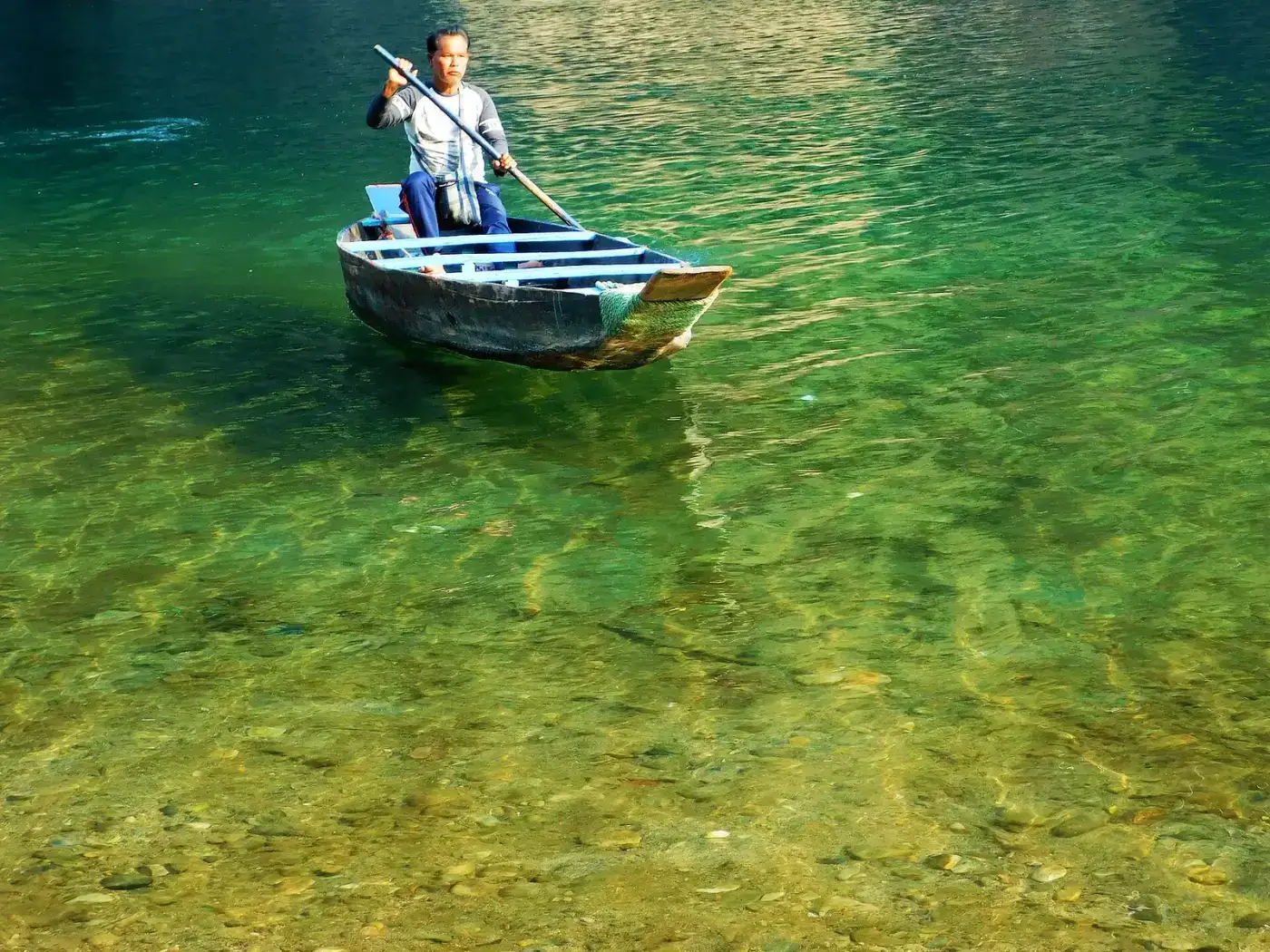 Boat floating on the emerald Umngot river
