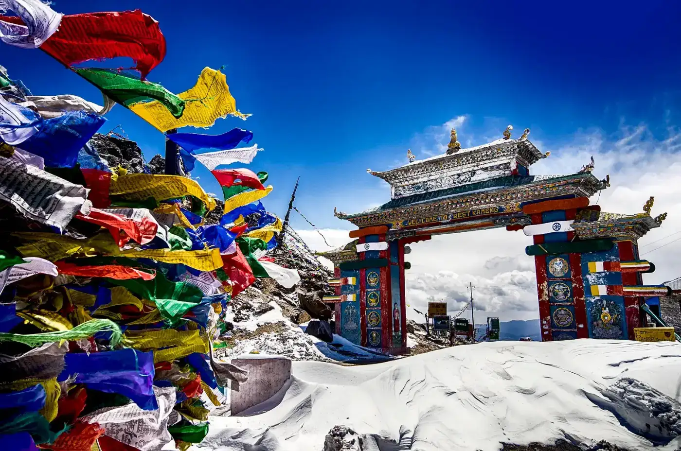 Snow-covered Sela Pass gateway with prayer flags in winter