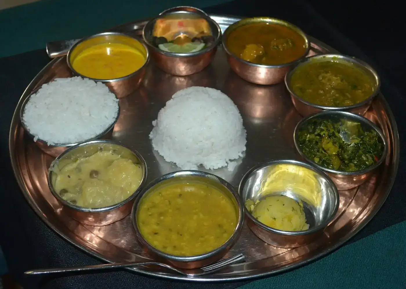 Traditional Assamese thali with rice, dal, fish curry and greens