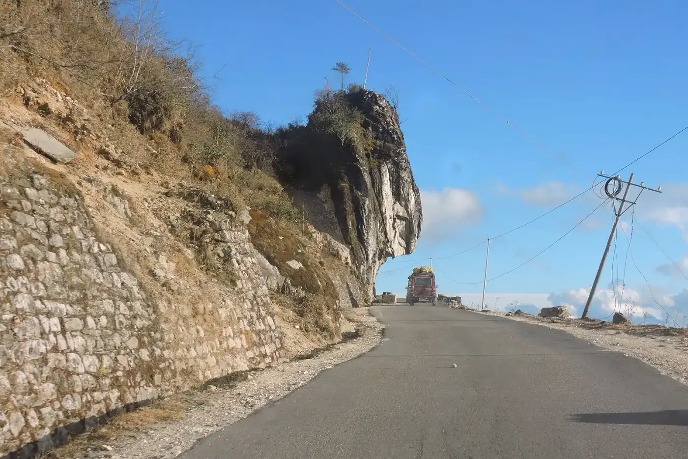Mountain road cut into a cliff on the route to Tawang