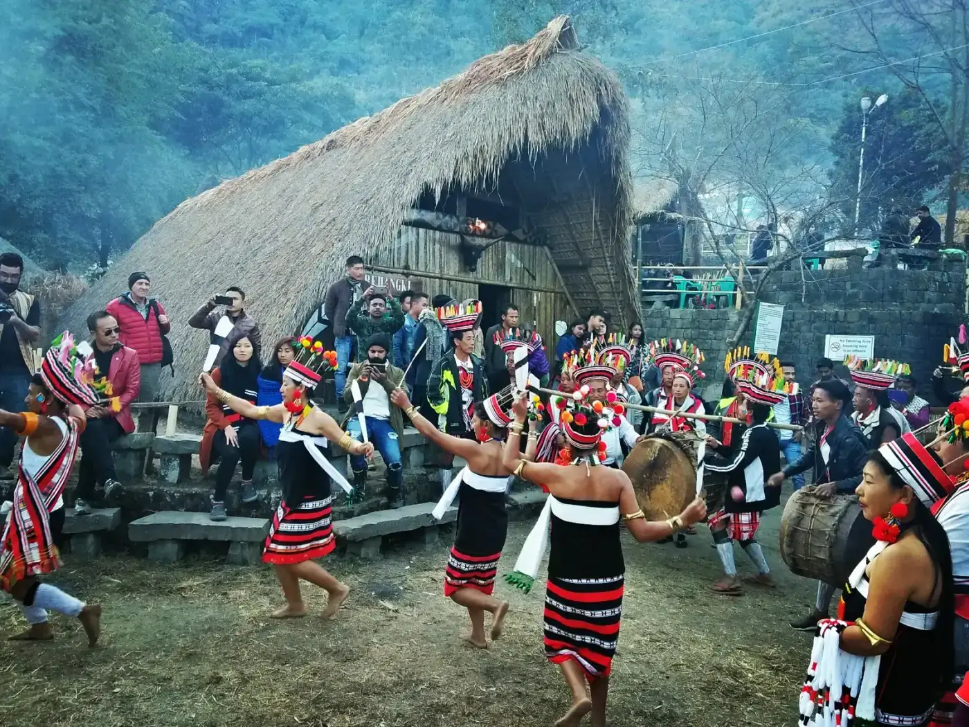 Tribal dance in front of a morung at the Hornbill Festival, Kisama