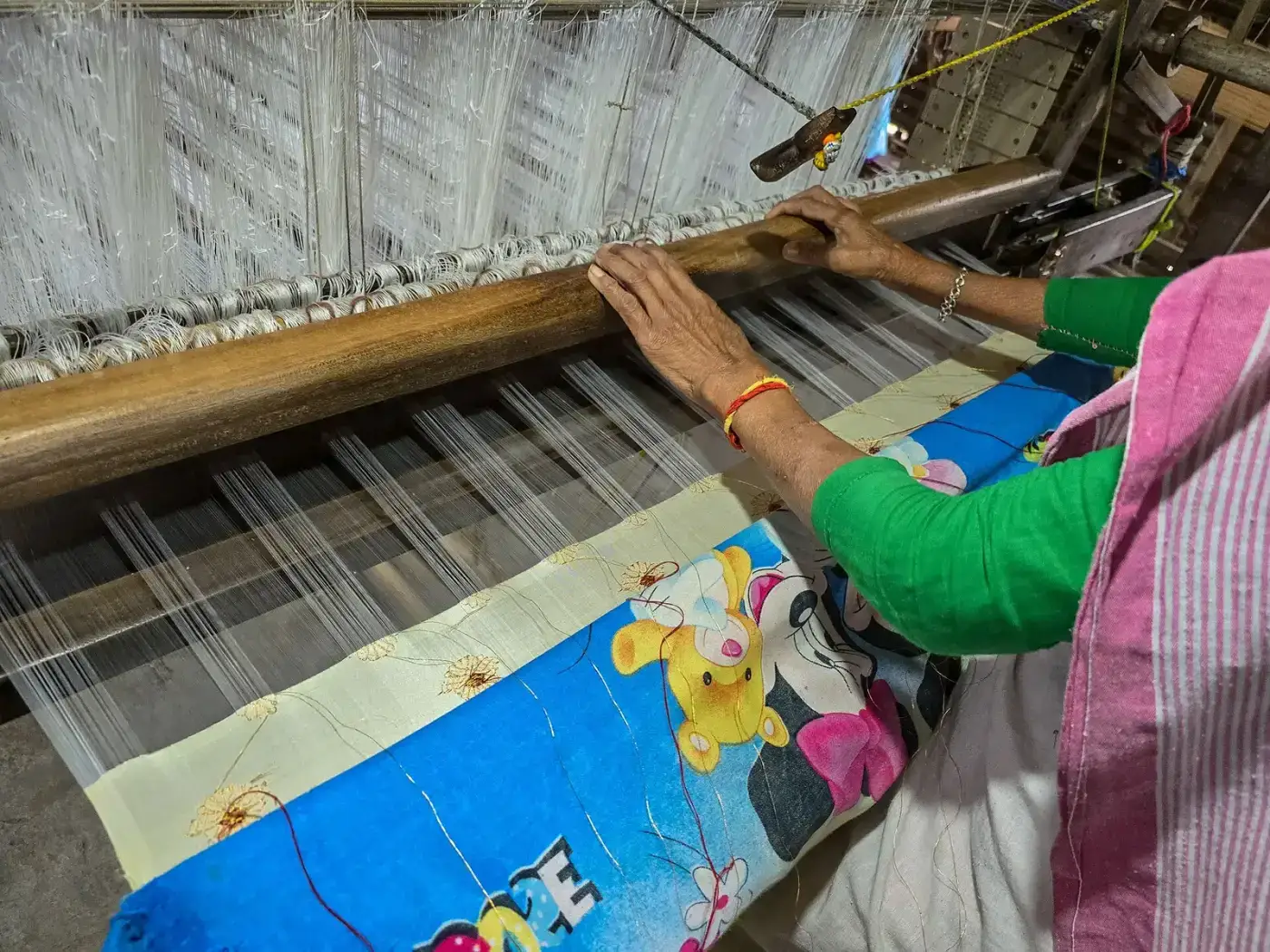 Weaver working on a silk handloom in Sualkuchi, Assam
